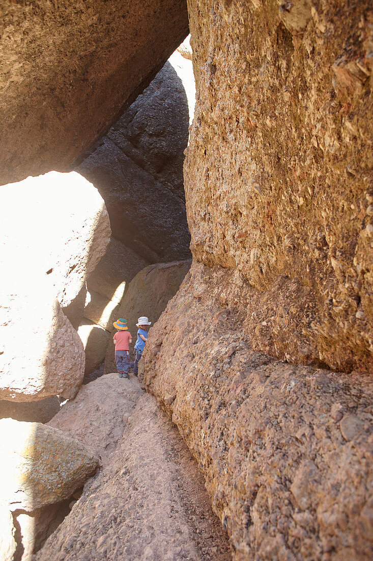 Children climb in the rocks of Pinnacles National Park, California, USA.