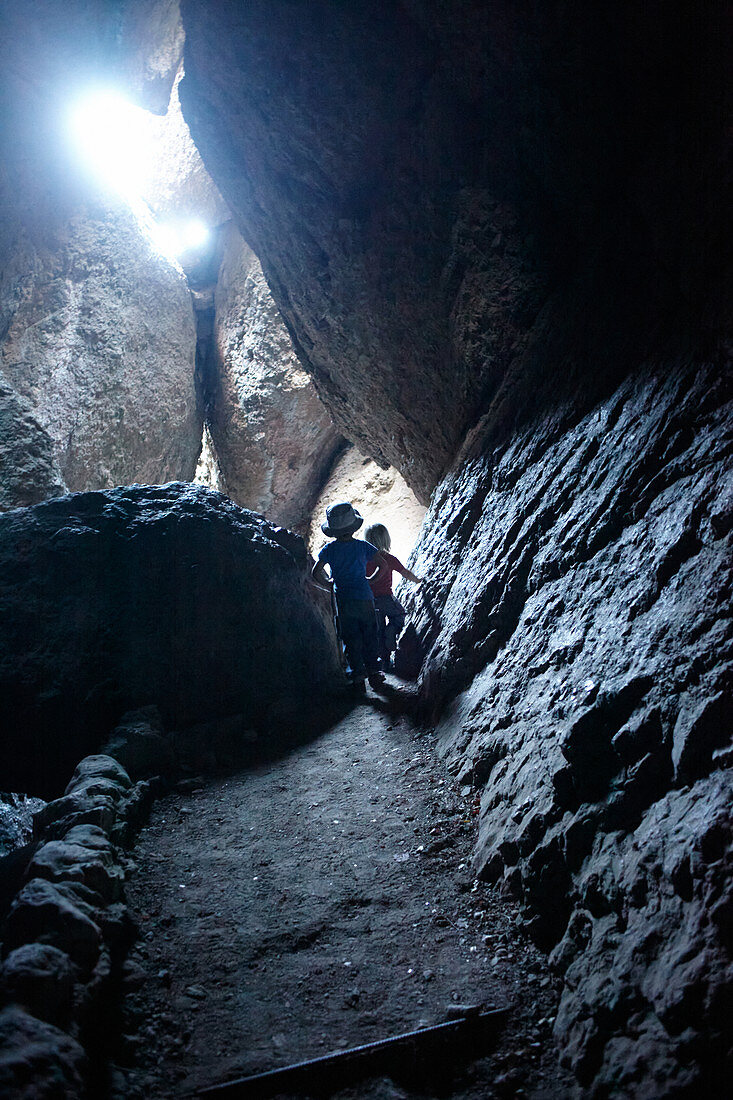 Children in a cave in Pinnacles National Park, California, USA.