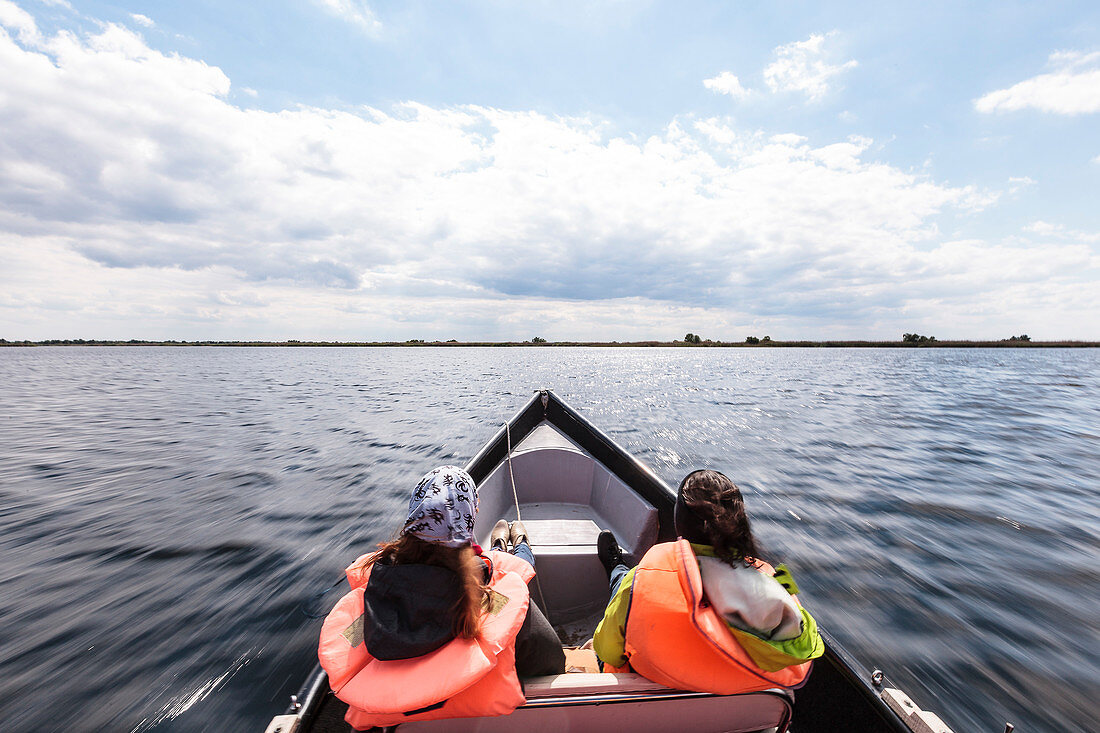 Tourists on a boat trip in the Danube Delta at Lacul Trei Iezere, Mila 23, Tulcea, Romania.
