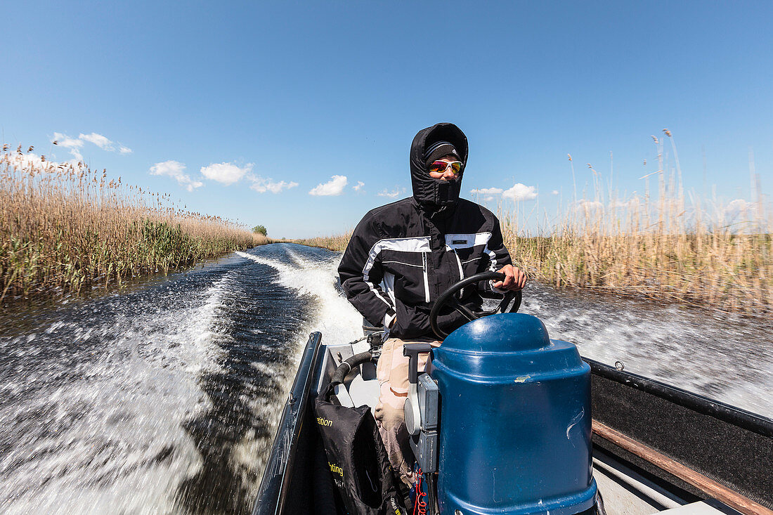 Bootsfahrt im Donaudelta, der Fahrtwind im April ist eisig, Sulina, Tulcea, Rumänien.