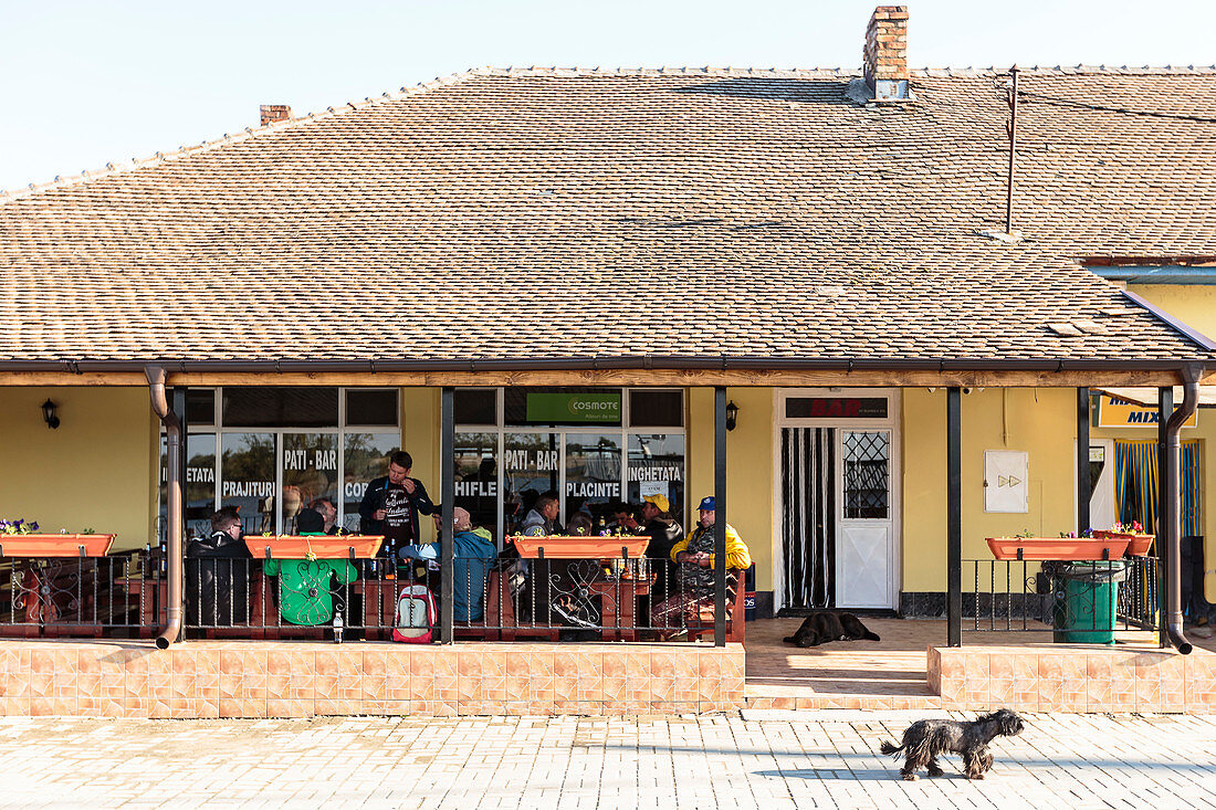 Donaudelta: Männer sitzen vor dem Dorfrestaurant in Mila 23, Tulcea, Rumänien.