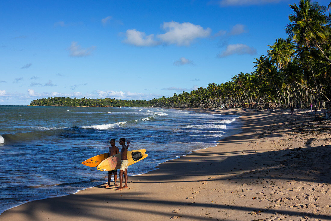 Junge Männer mit Surfbrettern am Strand, Praia da Cueira, Insel Boipeba, Bahia, Brasilien, Südamerika