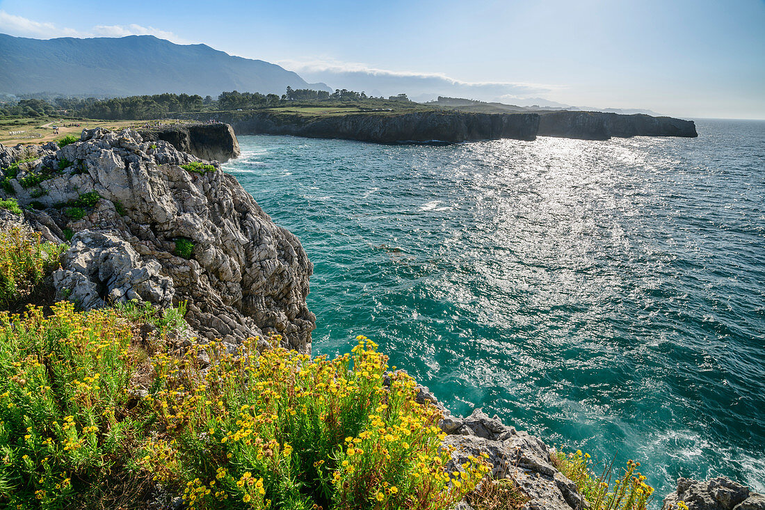 Sea on the steep coast of Playa de Guadamia, Bufones de Pria, mountains of the Picos de Europa in the background, Llames, Asturias, Spain