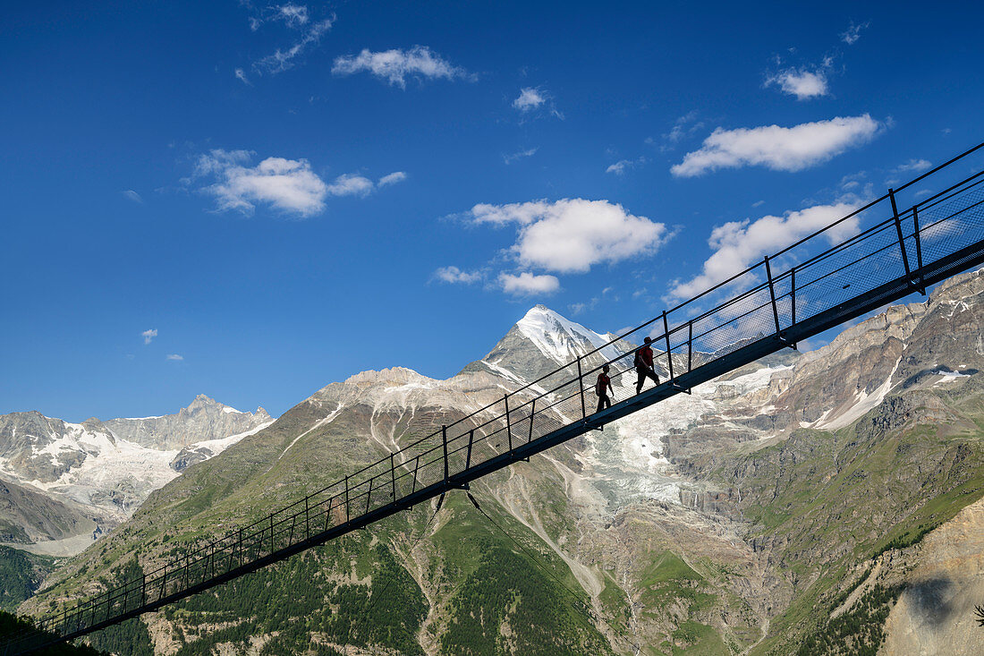 Two people walk over the Kuonen suspension bridge, longest suspension bridge in the world, Weißhorn in the background, Kuonen suspension bridge, Europaweg, Randa, Valais Alps, Valais, Switzerland
