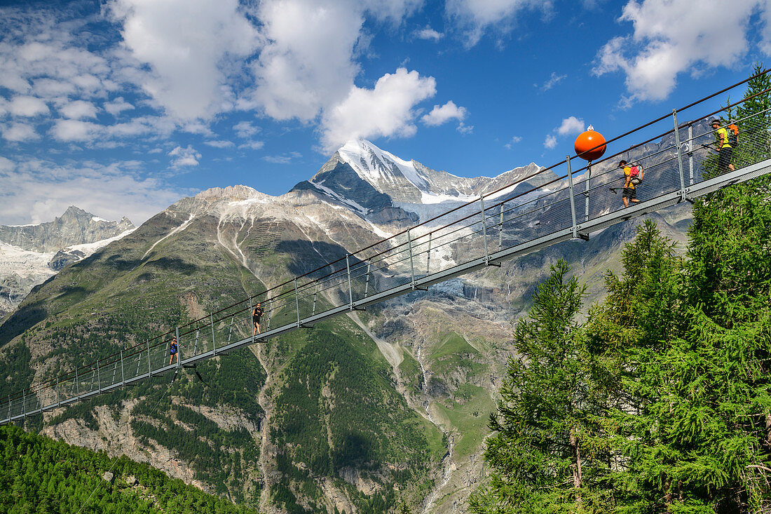 Mehrere Personen gehen über Kuonen-Hängebrücke, längste Hängebrücke der Alpen, Weißhorn im Hintergrund, Europaweg, Randa, Walliser Alpen, Wallis, Schweiz