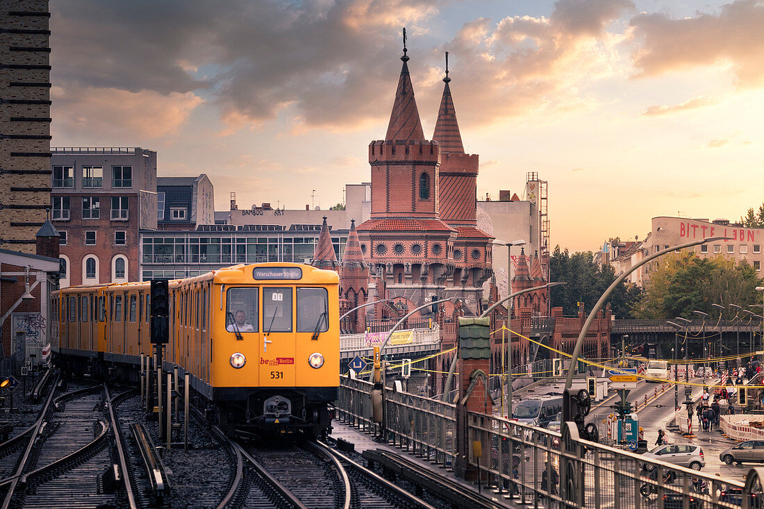 Panoramic view of Berliner U-Bahn with Oberbaum Bridge in the background in golden evening light at sunset. Friedrichshain-Kreuzberg district, Berlin, Germany