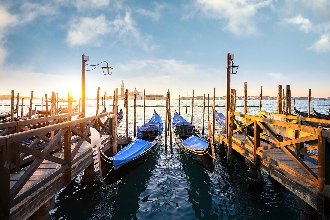 Gondolas near St Mark Square with San Giorgio Island on the background during sunrise. Venice, Veneto, Italy.