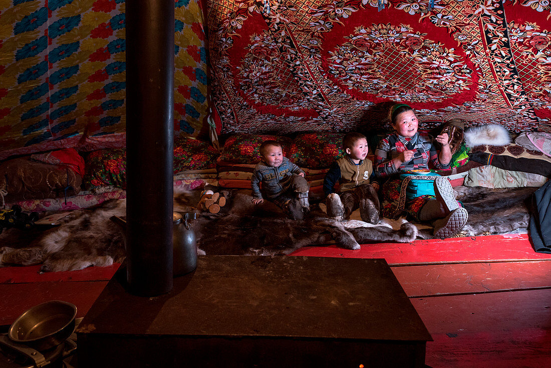 Nenets family in the tend. The traditional way of daily life at the nomadic reindeer herders camp. Polar Urals, Yamalo-Nenets autonomous okrug, Siberia, Russia