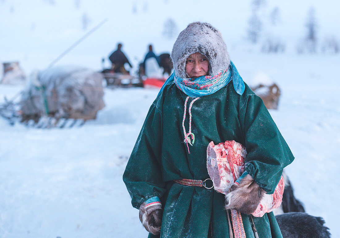 Nenets Frau gekleidet in traditioneller Weise im nomadischen Rentierhirtenlager. Polar Ural, Yamalo-Nenets autonomer Okrug, Sibirien, Russland