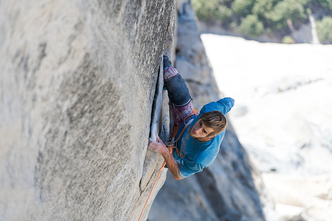 High angle view of mountaineer climbing up sheer wall of The Nose, El Capitan, Yosemite National Park.