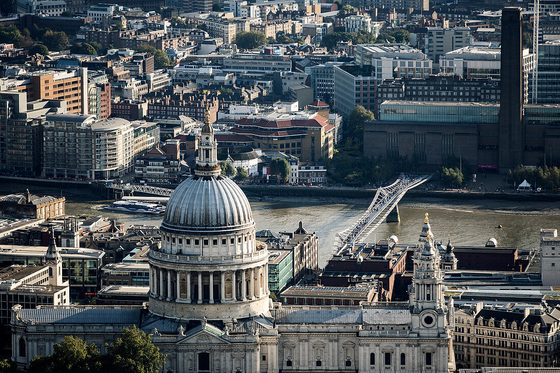 High angle view of the dome of St Paul's Cathedral designed by Christopher Wren, and Millennium Bridge and Tate Modern across the River Thames in London
