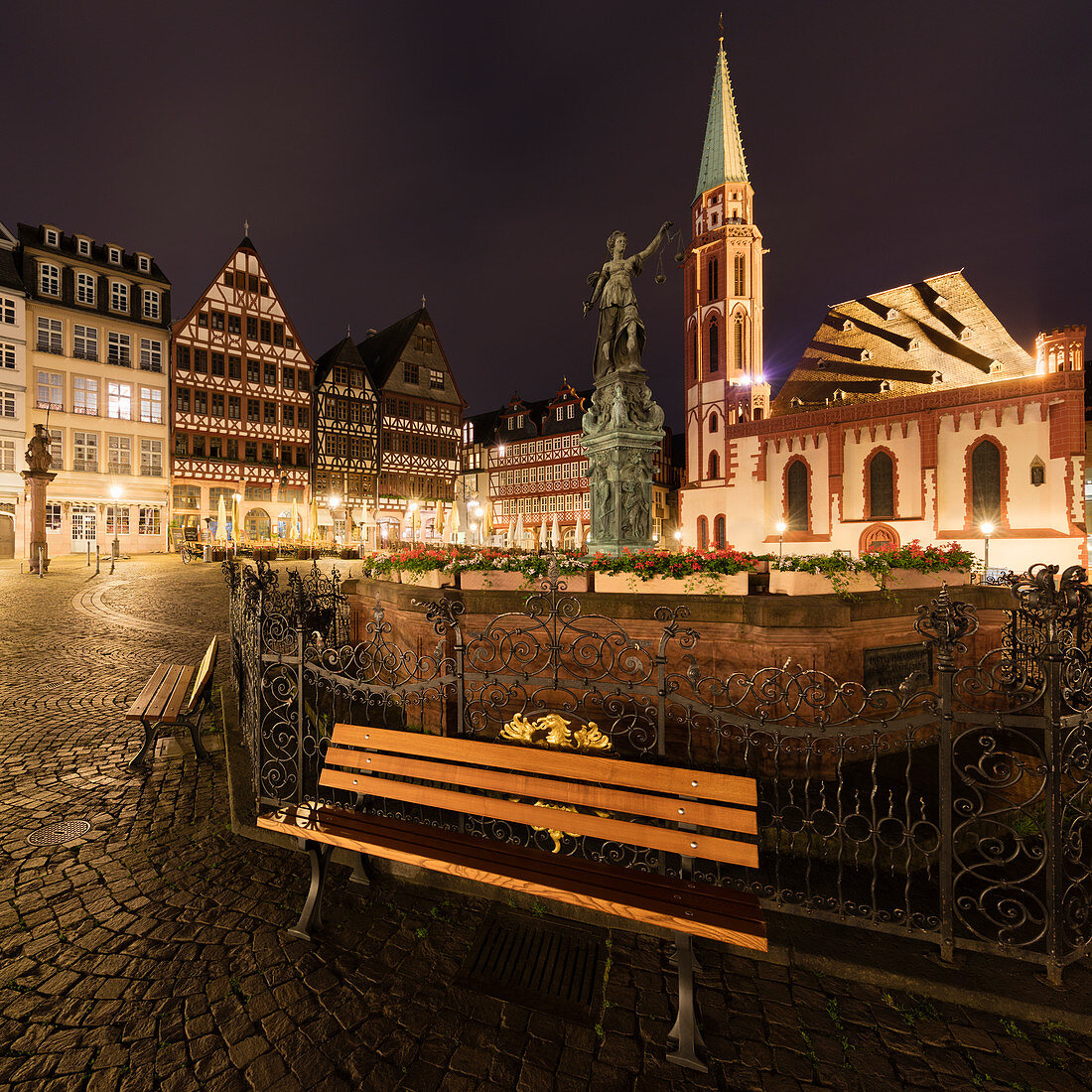 Empty bench on Romerberg in Frankfurt, Germany at night,  during the Corona virus crisis.