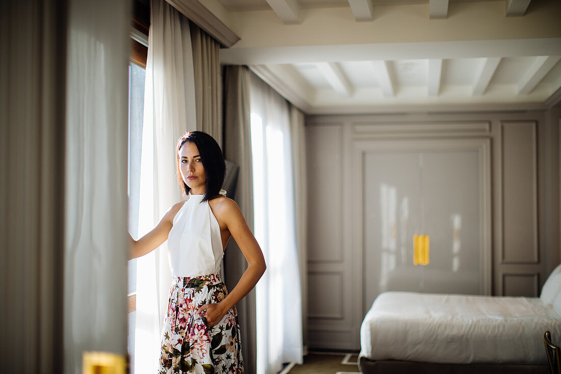 Fashionable woman beside window in suite