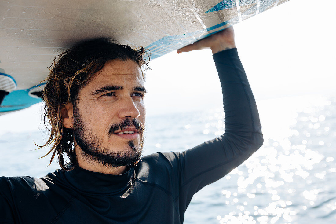 Surfer with surfboard by seaside