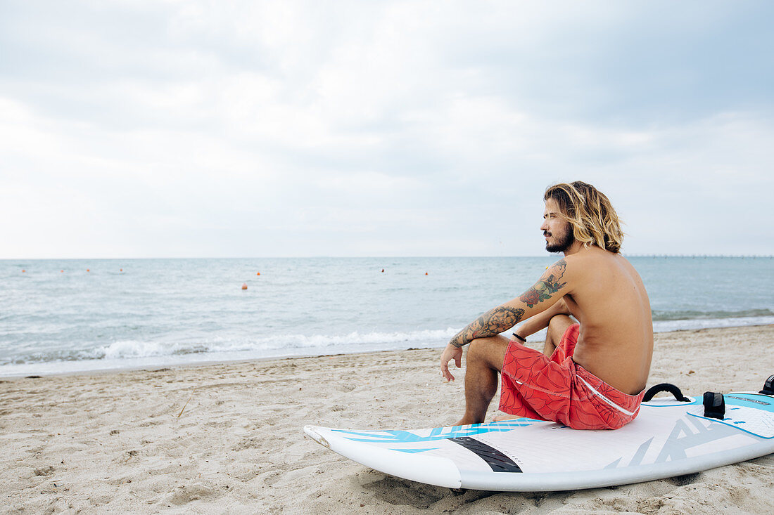 Surfer mit Surfbrett am Meer