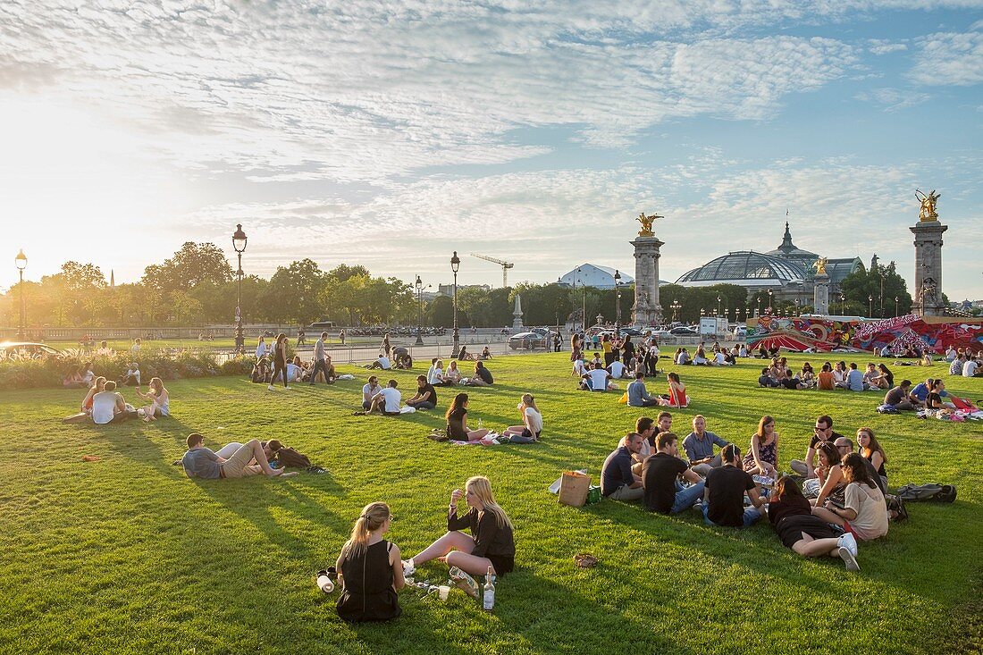 France, Paris, Esplanade des Invalides, picnic on summer evenings and the Grand Palais in the background