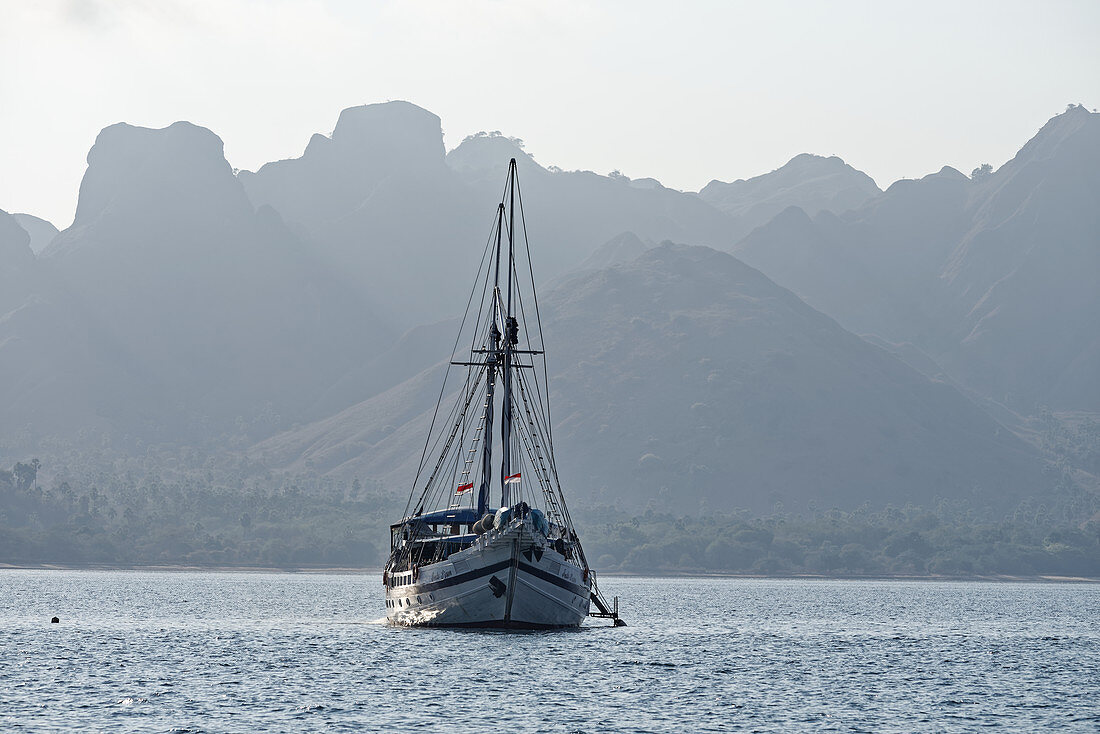 Boat in front of the bizarre mountain backdrop of Komodo, Indonesia, Southeast Asia, Asia