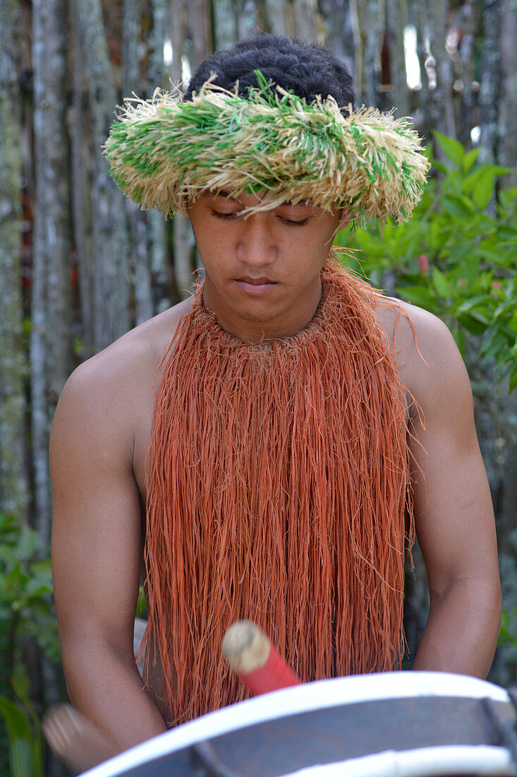 Cook Islander man plays music on a large drum instrument in Rarotonga, Cook Islands. Real people. Copy space