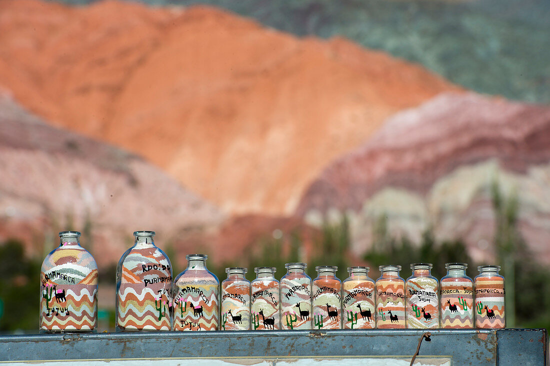 Souvenirflaschen mit buntem Sand aus den Felsformationen des Cerro de los Siete Colores (Hügel mit sieben Farben) in den Anden in Purmamarca, Provinz Jujuy, Argentinien.