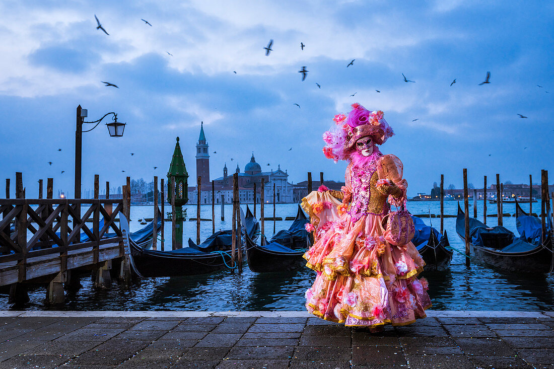 Typische Maske des Karnevals von Venedig in Riva degli Schiavoni mit der Insel St. George im Hintergrund, Venedig, Venetien, Italien