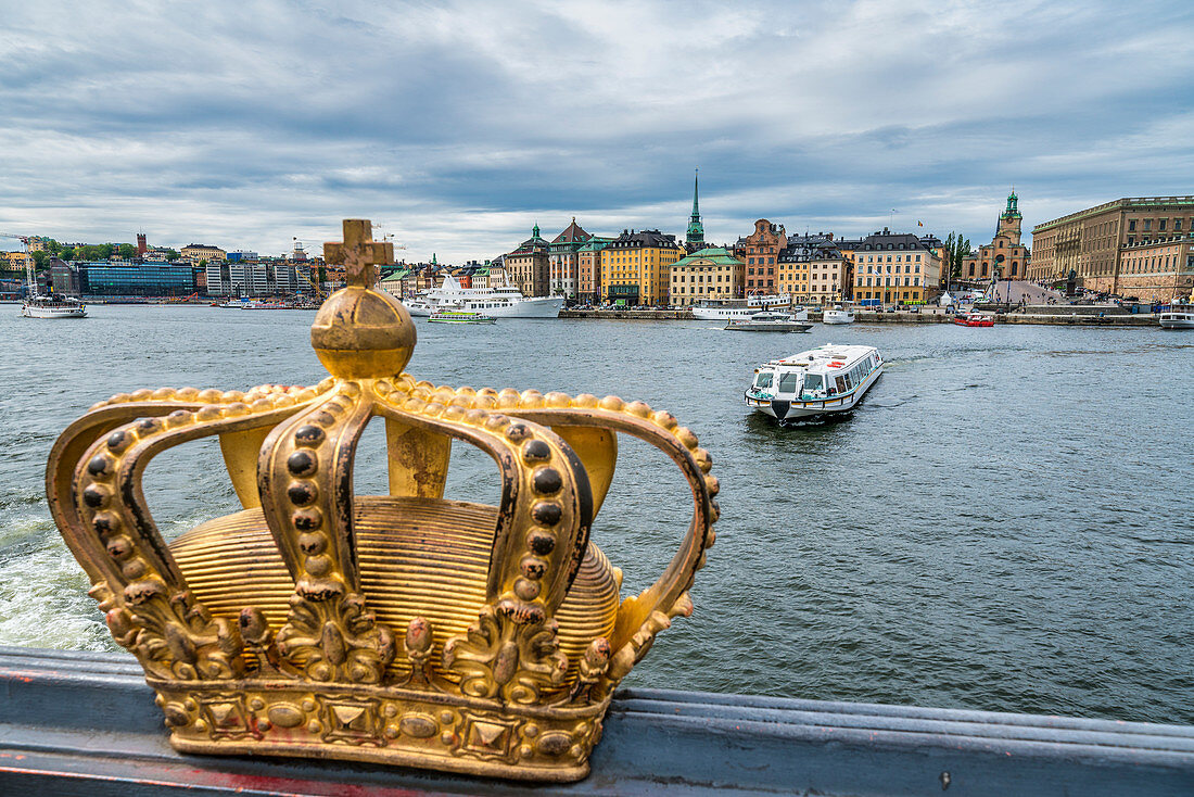 Gilded Crown on Skeppsholmsbron (Skeppsholm Bridge) with Gamla Stan old town in background, Stockholm, Sweden