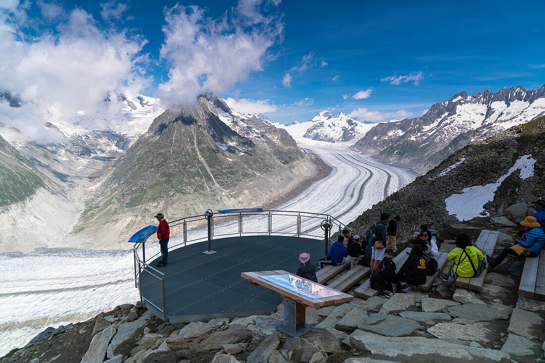 Menschen, die den majestätischen Aletschgletscher von der Terrasse am Aussichtspunkt Eggishorn, Berner Alpen, Kanton Wallis, Schweiz bewundern