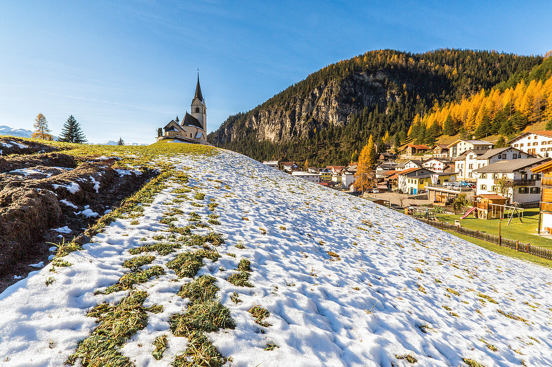 The church of Schmitten surrounded by colorful woods and snow Albula District Canton of Graubünden Switzerland Europe