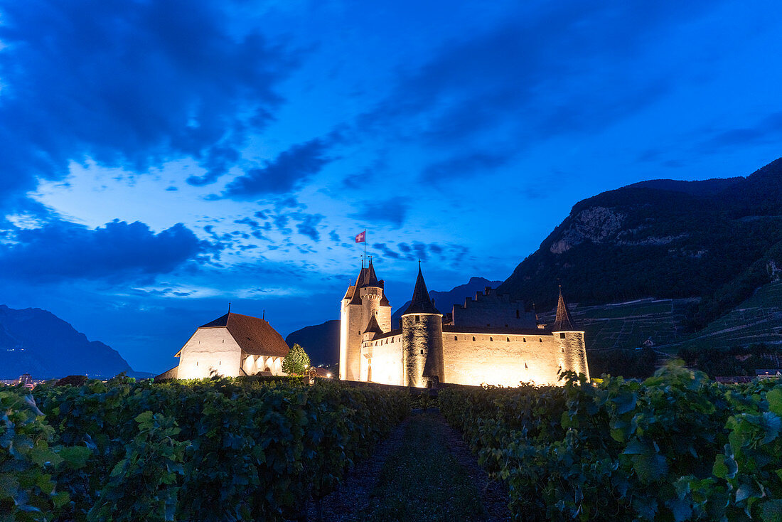 Aigle Castle beleuchtet in der Abenddämmerung, Kanton Waadt, Schweiz