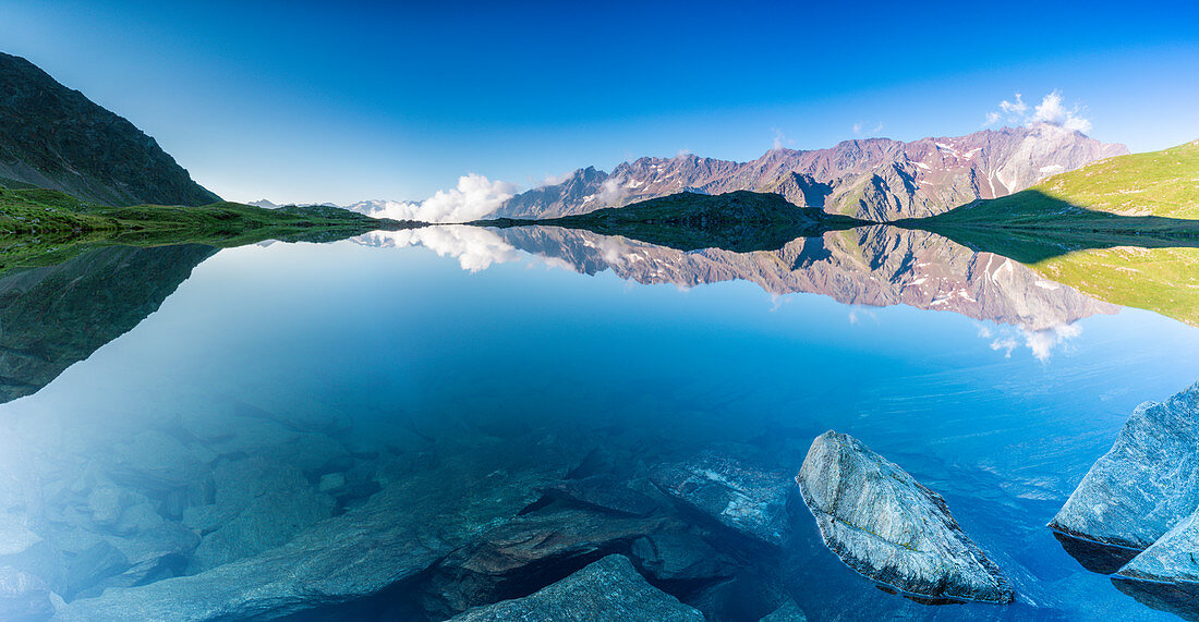 Panorama von Cima di Pietra Rossa gespiegelt in klarem Wasser des Lago Nero bei Sonnenaufgang, Gavia Pass, Valfurva, Valtellina, Lombardei, Italien