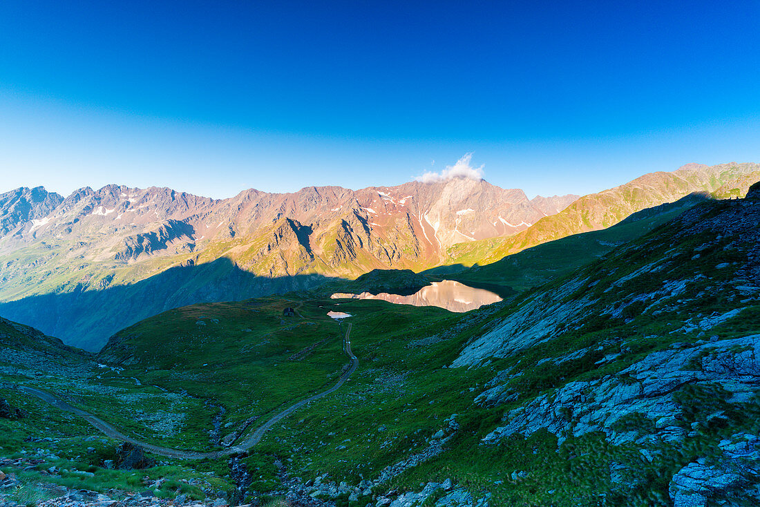 Cima di Pietra Rossa and Lago Nero lit by sunrise, Gavia Pass, Valfurva, Valtellina, Sondrio province, Lombardy, Italy