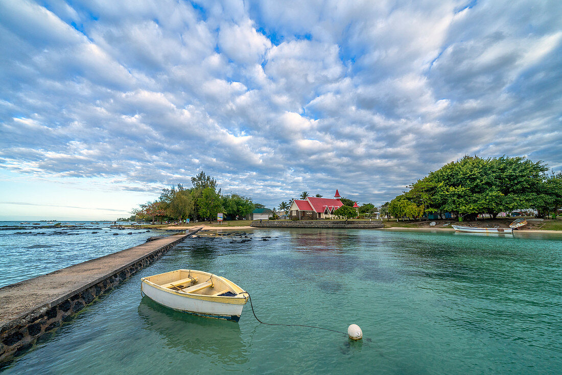 Dramatischer Himmel über der Kirche Notre Dame Auxiliatrice, gesehen vom Pier im türkisfarbenen Meer, Cap Malheureux, Indischer Ozean, Mauritius