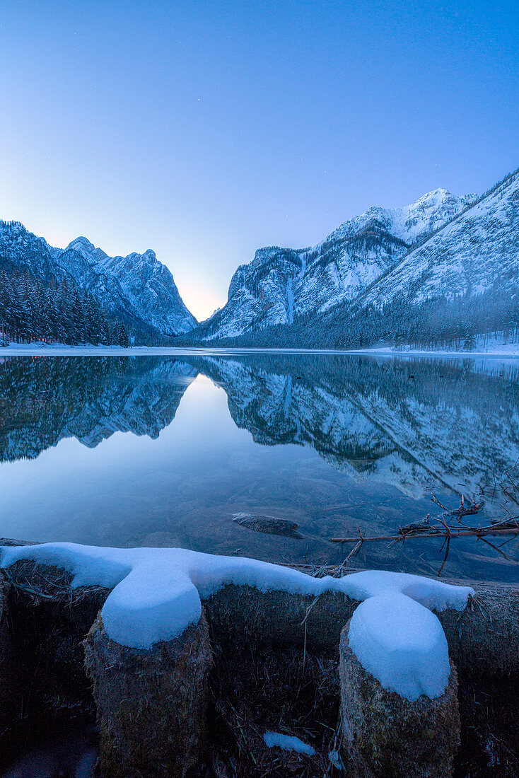 Dämmerung über See Dobbiaco und Berge im Winter, Dobbiaco, Val Pusteria, Dolomiten, Provinz Bozen, Südtirol, Italien