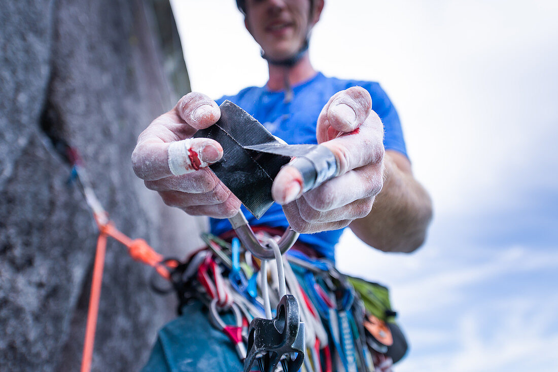 Kletterer bandagiert blutenden Finger, Trad Climbing, Stawamus Chief, Squamish, British Columbia, Kanada
