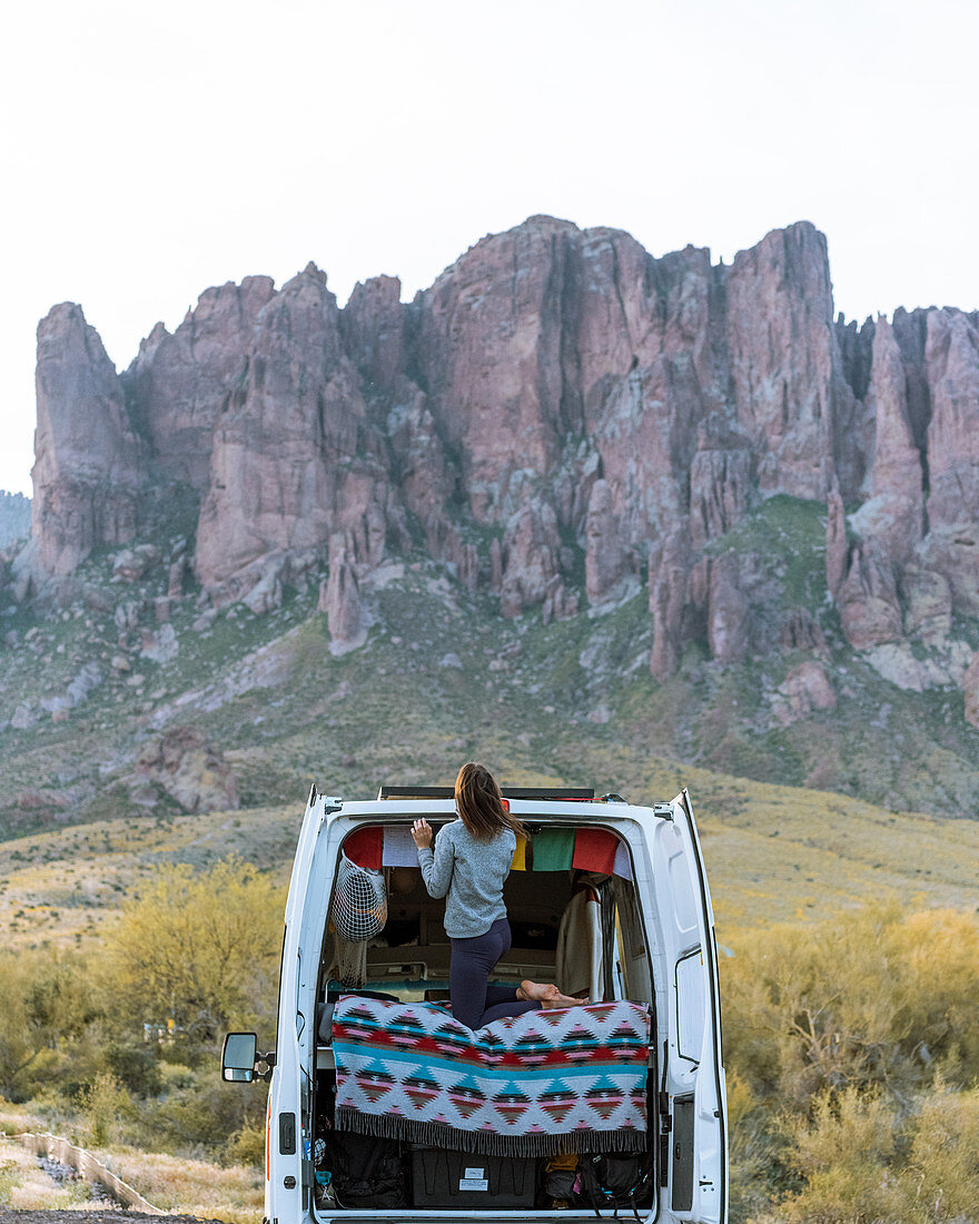 Frau im Geländewagen, die Superstition Mountain im Hintergrund, Arizona, Vereinigte Staaten