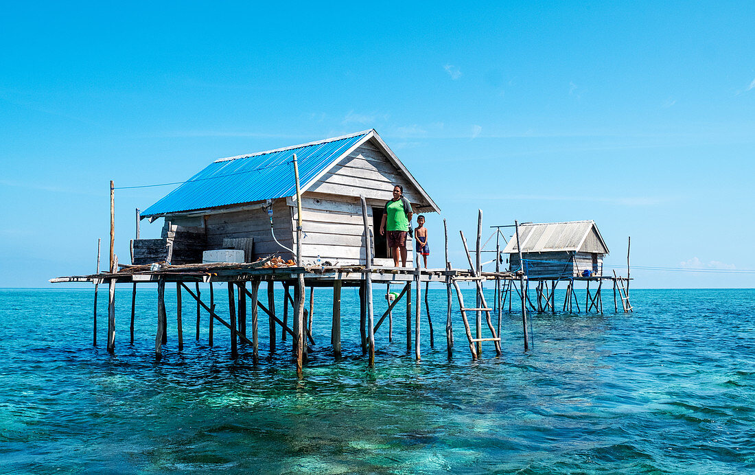 Frauen und Jungen in einer Hütte, die von Bajau-Fischern, die dort drei Monate lang leben, über dem Wasser gebaut wurden, Togian Islands, Indonesien, Südostasien, Asien