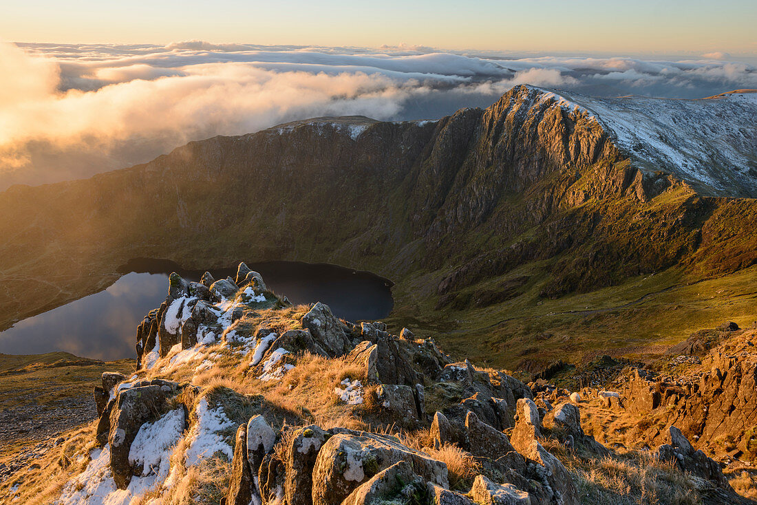 Morning light illuminates the top of Craig Cau during a cloud inversion, photographed from the top of Cadair Idris, Snowdonia, Wales, United Kingdom, Europe