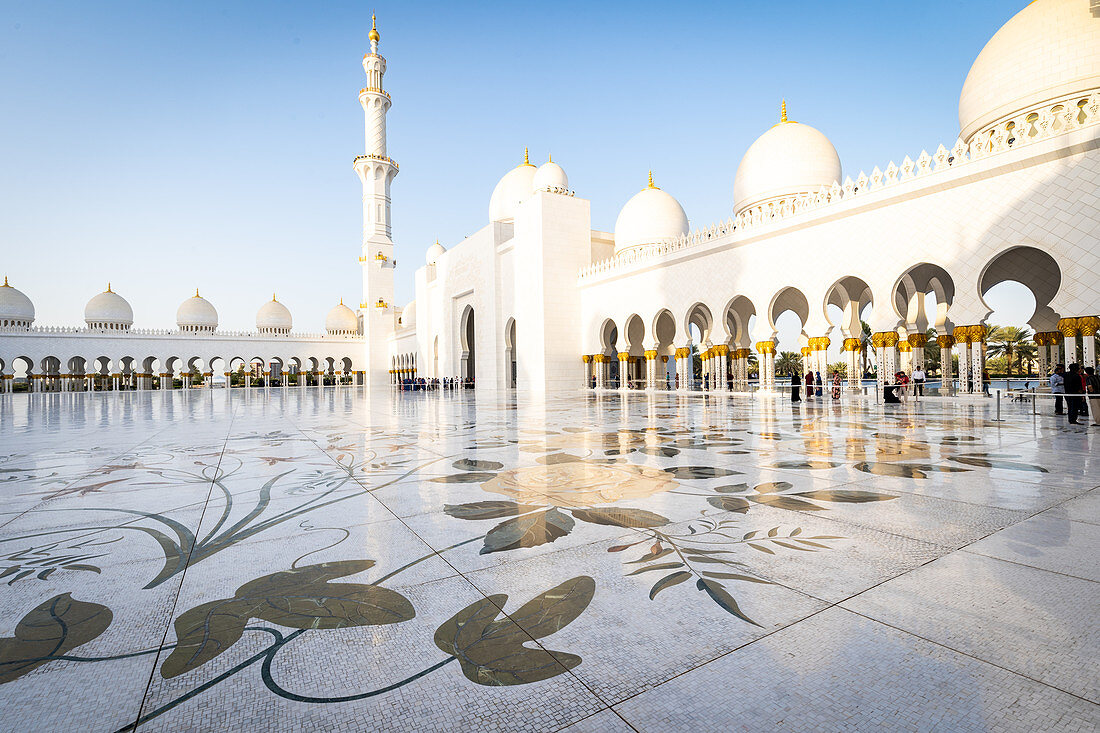 The domes and minarets of Abu Dhabi's Grand Mosque viewed across the large marble tiled central courtyard, Abu Dhabi, United Arab Emirates, Middle East