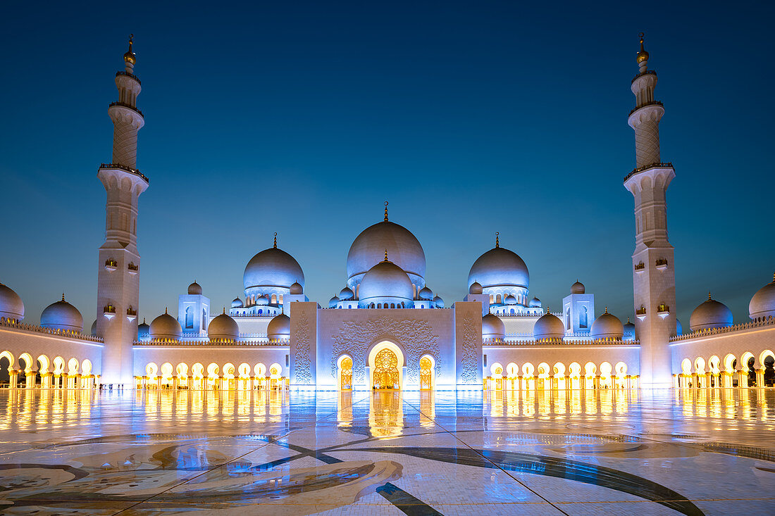 Abu Dhabis prächtige Große Moschee leuchtete während der abendlichen blauen Stunde in Abu Dhabi, Vereinigte Arabische Emirate, Naher Osten