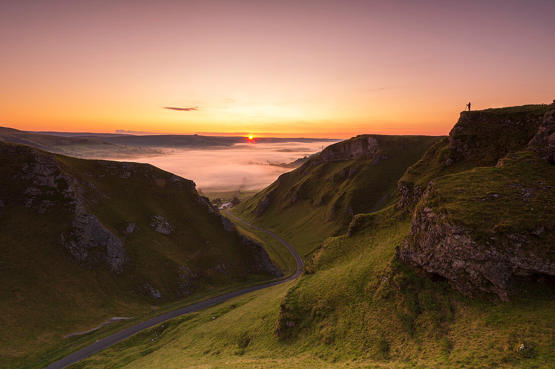 Ein Fotograf am Winnats Pass bei Sonnenaufgang, Hope Valley, Edale, Peak District, Derbyshire, England, Großbritannien, Europa