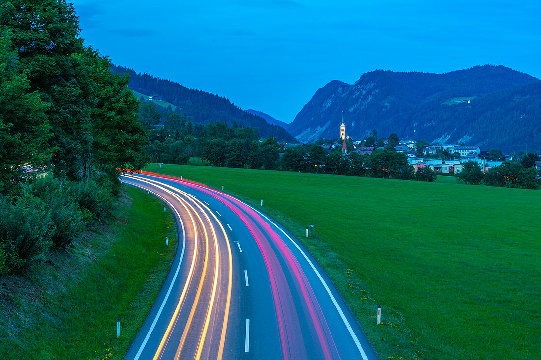 Trail lights and illuminated church in Radstadt at dusk, Radstadt, Styria, Austria, Europe