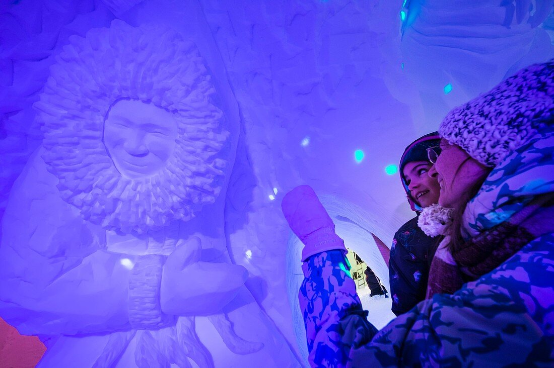 Frankreich, Savoie, Tarentaise-Tal, Vanoise-Massiv, Skigebiet Arcs 2000, eine Mutter zeigt ihrer Tochter während der Wintersaison 2017-2018 eine riesige Inuit-Schneeskulptur in der Wand des Iglu-Dorf-Barraums