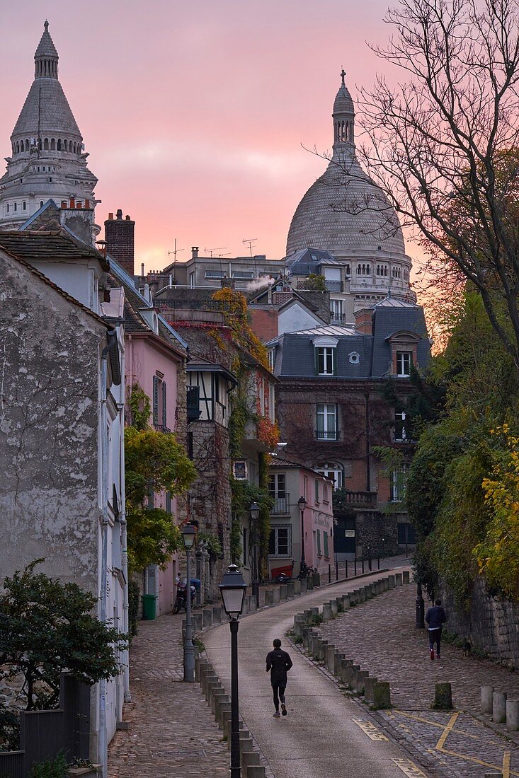 France, Paris, Paris, A man runs on the Abreuvoir Street in Montmartre at sunrise