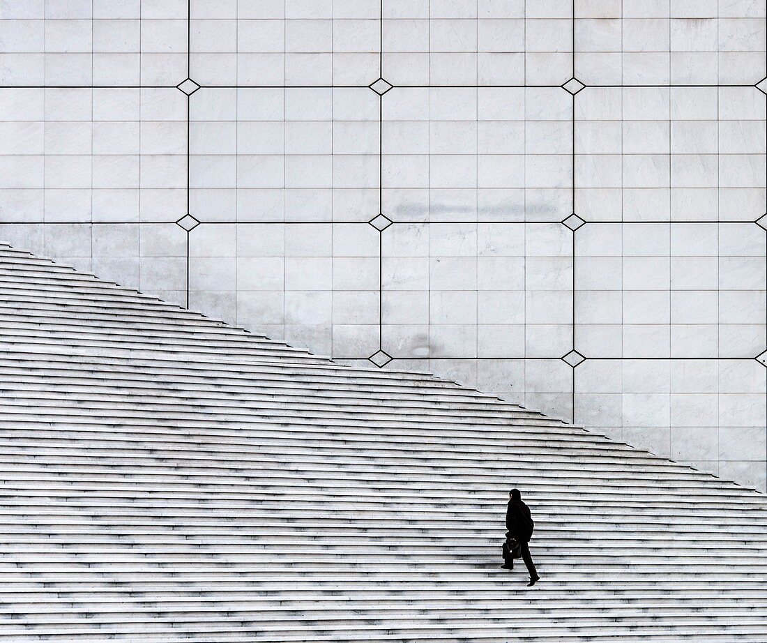 Frankreich, Hauts de Seine, Puteaux, ein Mann steigt die Treppe der Grande Arche de la Défense hinauf