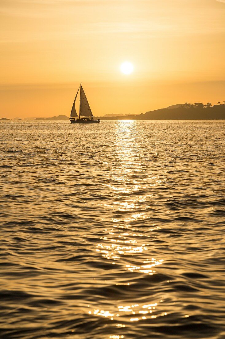 France, Manche, Saint Jacut de la Mer, sunrise on a sailboat with Ile des Ebihens in the background