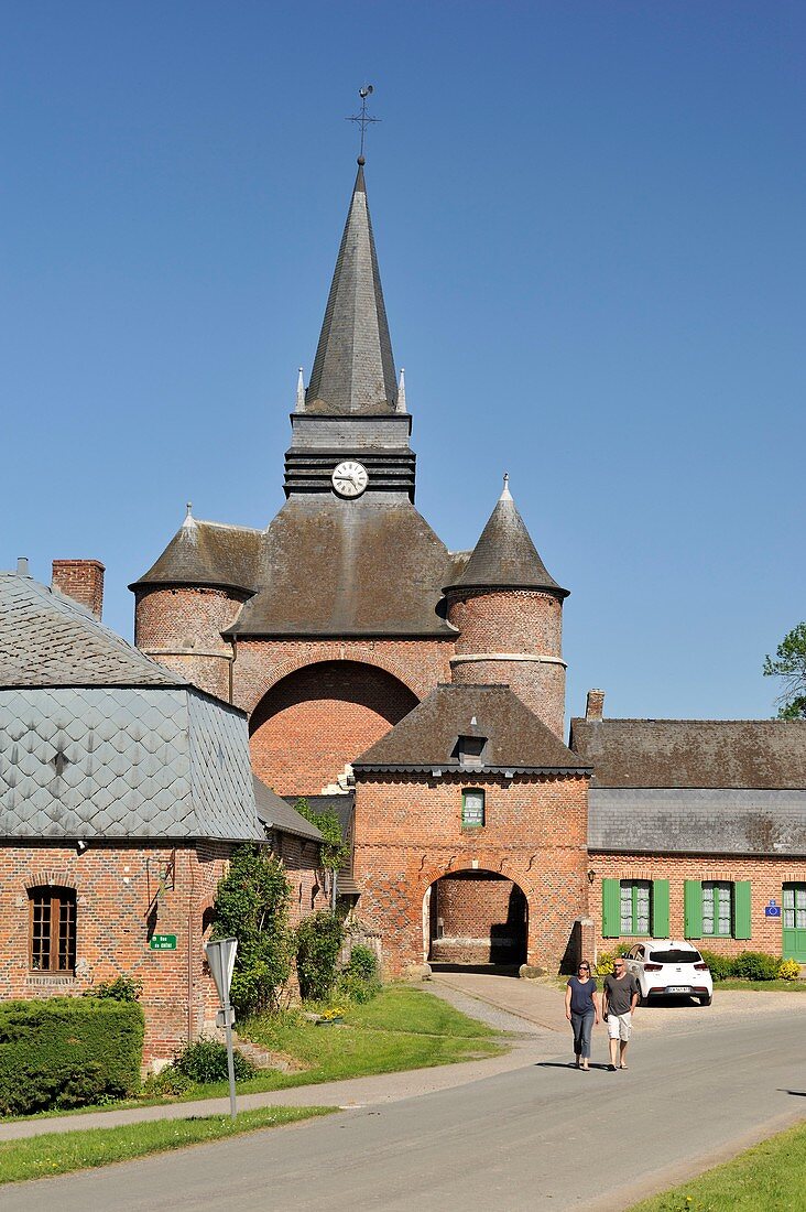 France, Aisne, Parfondeval, labeled the Most Beautiful Villages of France, Saint Medard fortified church, couple to walk
