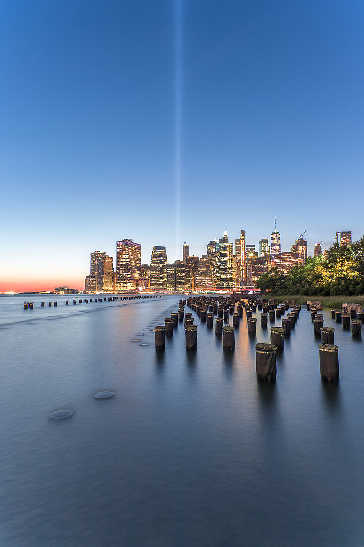 View across the water of New York City,Manhattan island,at dawn,flat calm water.