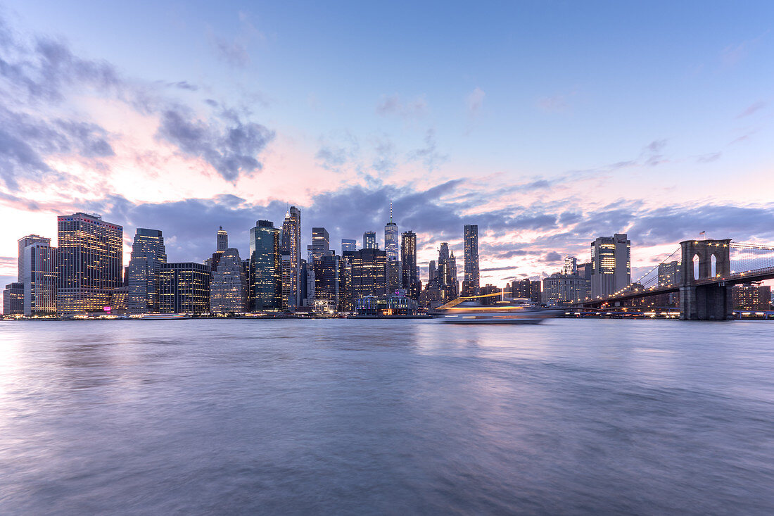 View across the water of New York City,Manhattan island,at dawn,flat calm water.