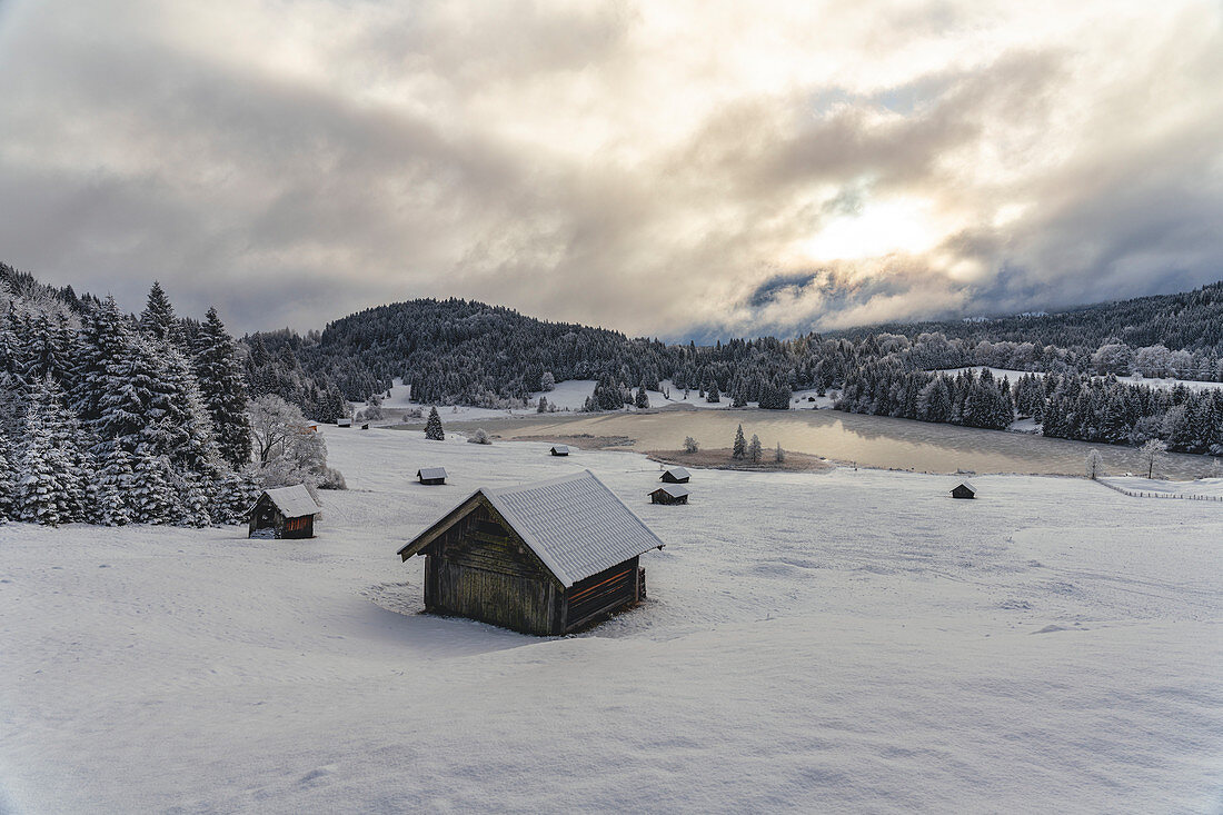 View over the frozen Geroldsee to snow-covered landscape, Krün, Bavaria, Germany.