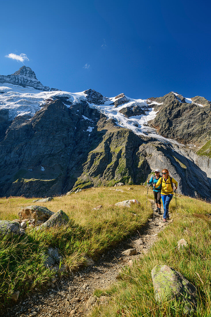 Man and woman hiking up to the Glecksteinhütte, Klein Schreckhorn in the background, Glecksteinhütte, Bernese Oberland, UNESCO World Natural Heritage Swiss Alps Jungfrau-Aletsch, Bernese Alps, Bern, Switzerland