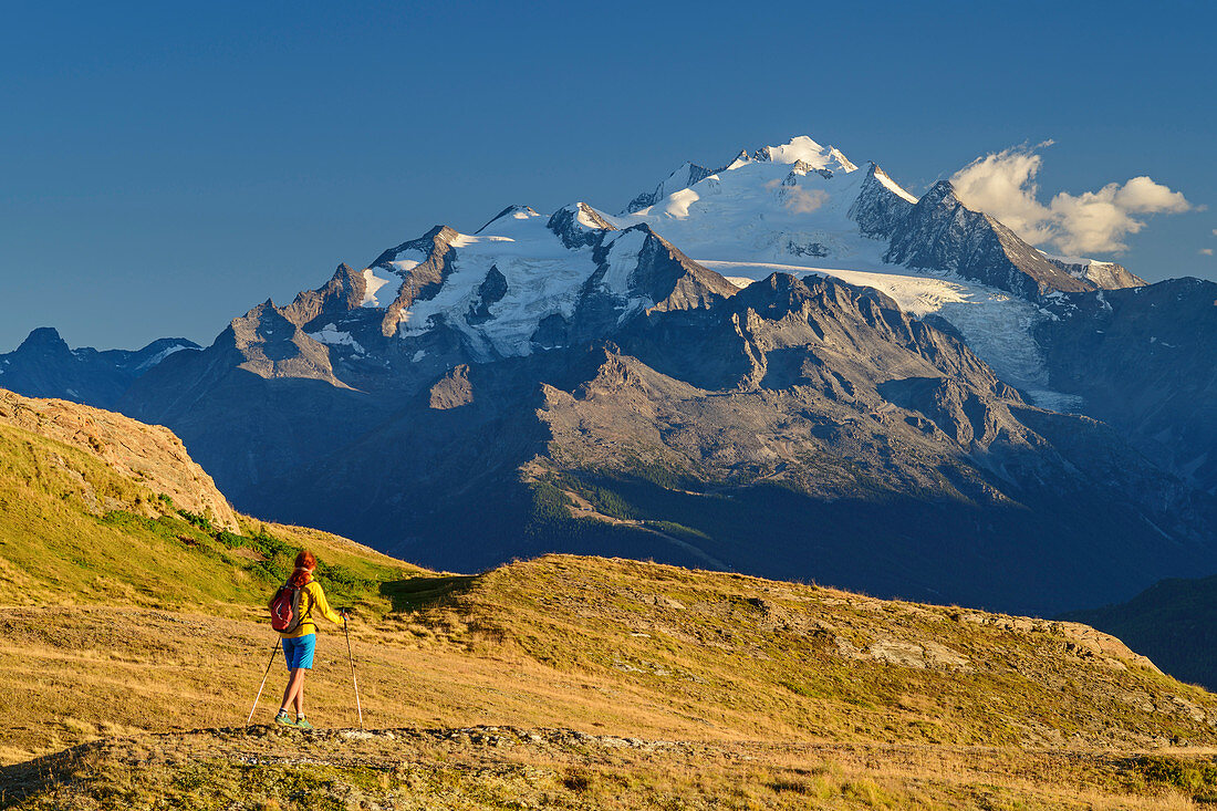 Woman hiking with cathedral in the background, Wiwannihütte, Bernese Alps, Valais, Switzerland